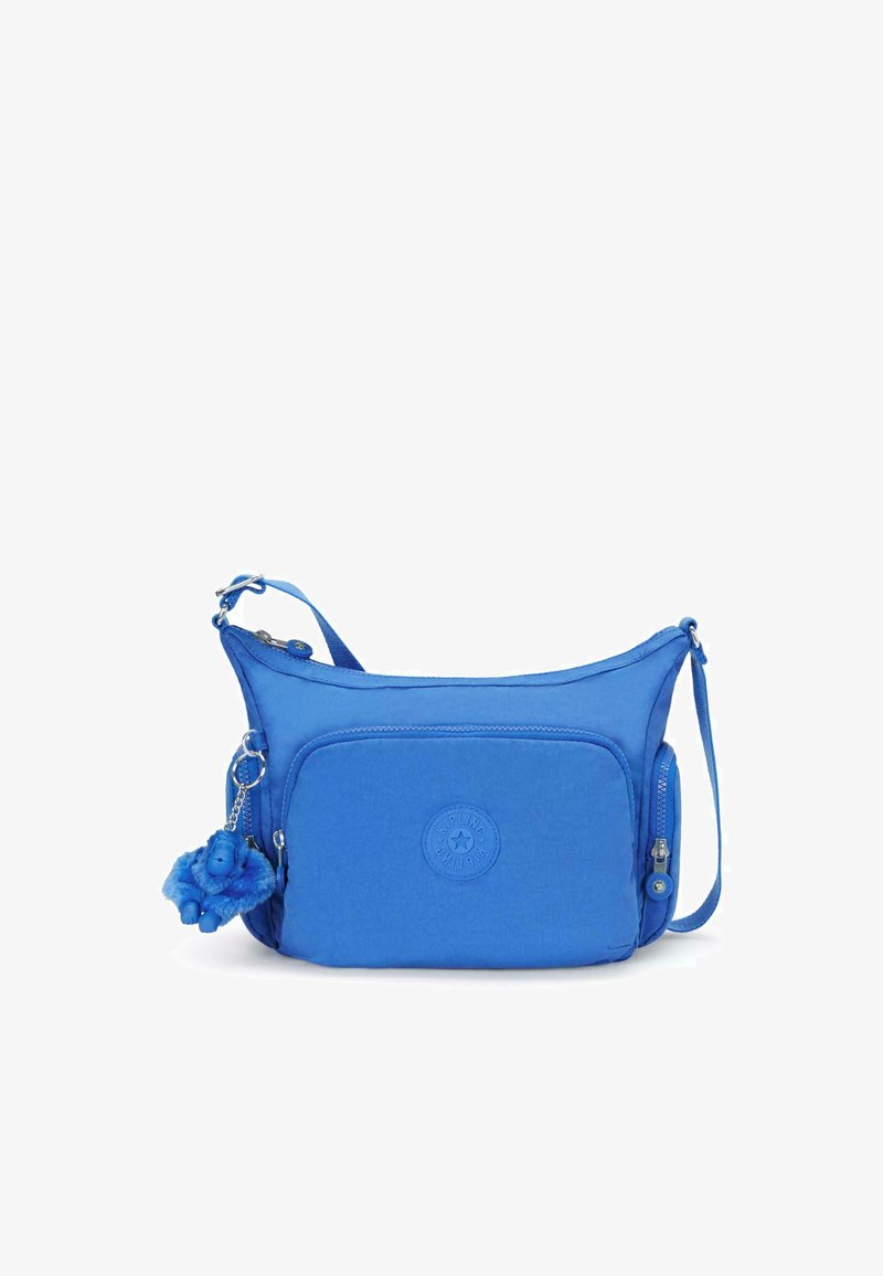 Royal blue crossbody bag with a textured finish, featuring a zippered compartment, a circular logo, and a furry blue monkey keychain.