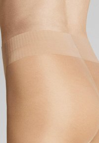 Beige nahtlose Strumpfhosen mit einem weichen, transparenten Finish und einem strukturierten Bund, ausgestattet mit einem glatten und dehnbaren Stoff für zusätzlichen Komfort.