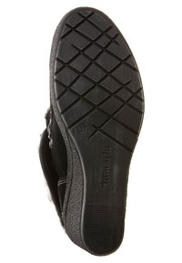 Suela de zapato de goma negra con un patrón de agarre texturizado, de la marca "Tamaris," con el indicador de talla "37" grabado en el lateral.
