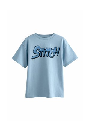 Camiseta de algodón azul clara con un gran gráfico en negrita que dice "STITCH" en azul oscuro. Manga corta y diseño de cuello redondo. Textura suave.