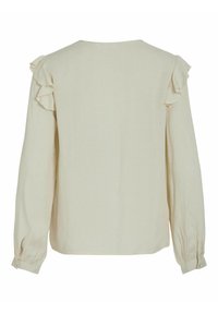 Langærmet bluse i lysebeige stof med rynkede ærmedetaljer, rund halsudskæring og knaplukning ved håndleddene. Glat tekstur med subtile mønstre.