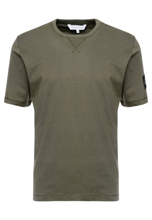 Oliwkowo-zielony t-shirt Calvin Klein Jeans z krótkim rękawem, okrągłym dekoltem i małą naszywką z logo na lewym rękawie.