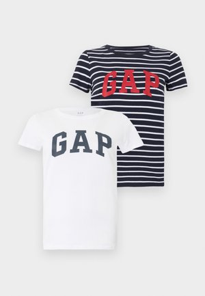 Two short-sleeve t-shirts, one white with black "GAP" text, one navy with white stripes and red "GAP" text, shown on light gray background.