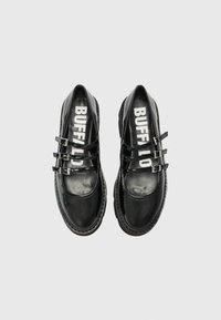 Black patent leather shoes with a rounded toe, featuring two strap closures, contrasting logo inside, and a textured rubber sole.