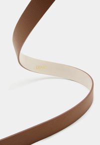 Cintura in pelle marrone con texture, dotata di una superficie interna liscia, caratterizzata da un sottile logo in oro. Design flessibile e curvato.