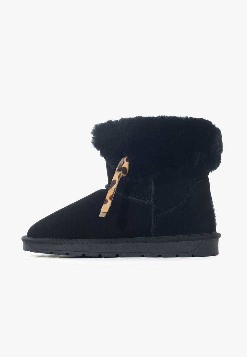 Stivali neri alla caviglia in suede con un colletto di pelliccia nera morbida. Presentano un accento in pizzo leopardato e una suola in gomma testurizzata.