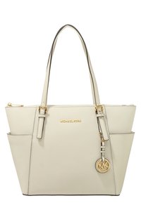 Beżowa torba tote Michael Kors z podwójnymi uchwytami, złotymi detalami, logo z przodu, kieszeniami po bokach oraz okrągłym charmem MK. Teksturowany materiał syntetyczny.