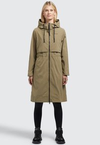 Impermeabile khaki con cappuccio, chiusura con zip frontale, vita elastica e cordini neri. Presenta maniche lunghe e arriva a metà polpaccio.