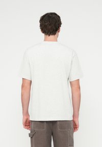 Ανοιχτό γκρι κοντομάνικο t-shirt με στρογγυλή λαιμόκοψη· κατασκευασμένο από μαλακό ύφασμα μείγματος βαμβακιού· απλός σχεδιασμός χωρίς ορατά σχέδια ή διακοσμήσεις.