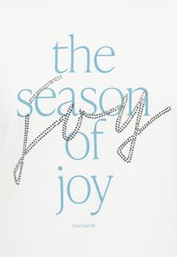 White t-shirt featuring blue text "the season of joy" with silver rhinestone accents. Text is in varying font sizes and styles.
