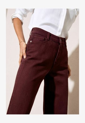 Bordo džinsai su tiesiu kirpimu, pagaminti iš džinsinio audinio. Yra klasikinis penkių kišenių dizainas ir sidabriniai apdailos elementai.