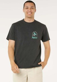 T-shirt nera in cotone con grafica frontale raffigurante palme e il nome del marchio in turchese. Maniche corte e collo a girocollo classico.