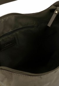 Olijfgroene stoffen tas met een gladde, gestructureerde binnenkant. Voorzien van een ritsvak en leren accenten met textuur. Voering aan de binnenkant.