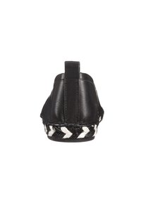 Zapato de cuero negro con un talón redondeado, que cuenta con un ribete decorativo de cuerda trenzada en blanco y negro a lo largo de la suela. Textura suave, diseño minimalista.