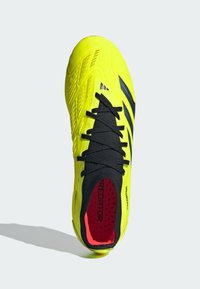 Chaussure de football jaune vif avec des accents et des lacets noirs. Tige texturée, design élégant et intérieur rembourré avec des détails rouges.