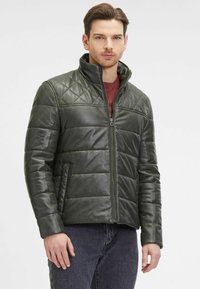 Giacca in pelle verde con design trapuntato, colletto alto, zip frontale e due tasche laterali. Texture liscia con sezioni imbottite.