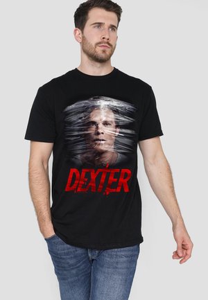 Black cotton t-shirt featuring a graphic of a face with a blurred effect and the text "DEXTER" in bold red, combined with blood splatter details.