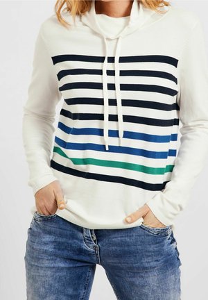Hooded pullover sweater in white with navy, blue, and green horizontal stripes. Knit fabric with ribbed cuffs, worn over blue jeans.