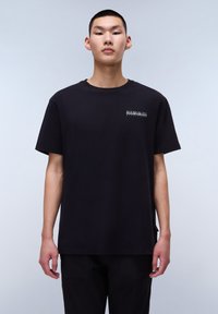T-shirt en coton noir avec une coupe décontractée, col rond, manches courtes et un petit logo blanc sur la poche gauche.
