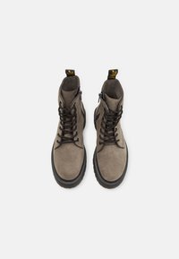 Bottines en daim gris avec lacets à l'avant, bout rond et semelle en caoutchouc. Équipées d'une languette de tirage et d'une fermeture éclair latérale pour un accès facile.