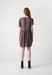 Kjole med leopardmønster, korte pufferm, tettsittende liv og rynket skjørt. Stoffet er lett og mykt. Brukt med svarte ankelstøvletter.