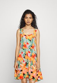 Vestido floral com flores em tons de laranja e rosa brilhantes sobre um fundo verde, sem mangas, com decote arredondado e cintura elástica.