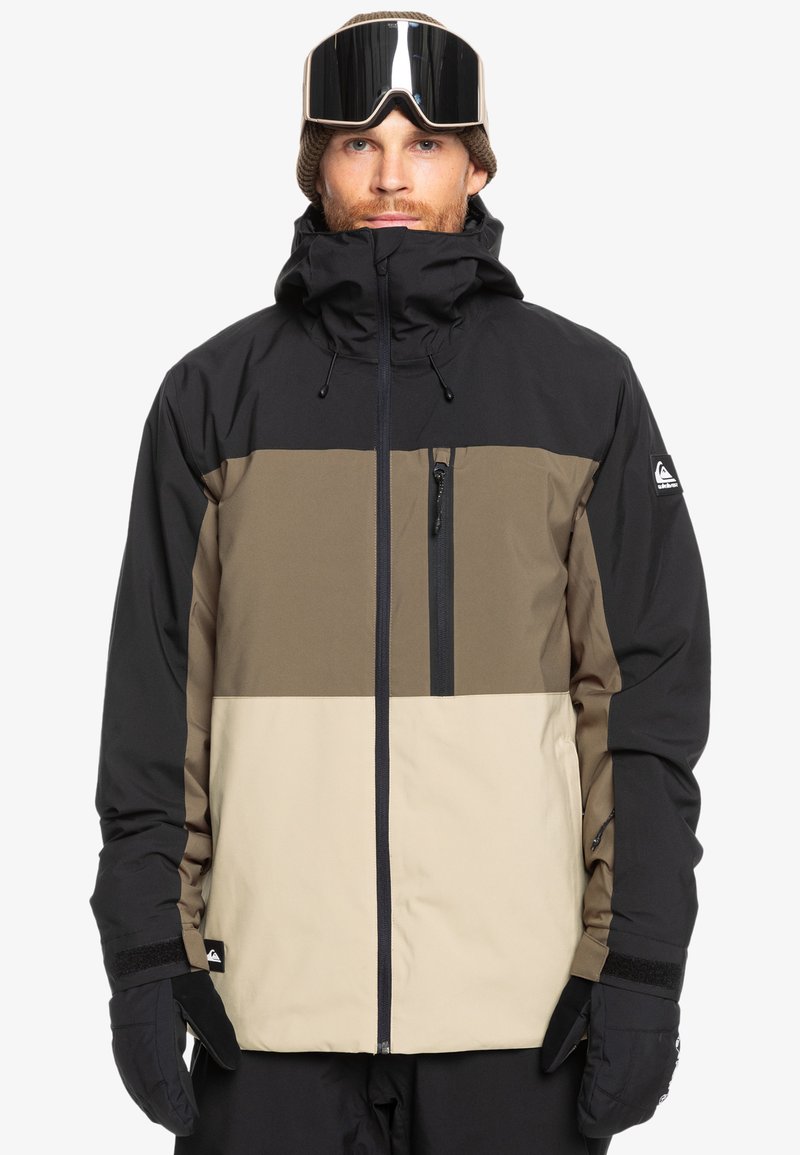 Herrenjacke mit Farbblockdesign in Schwarz, Braun und Beige, hohem Kragen, Reißverschlusstasche und verstellbaren Bündchen.