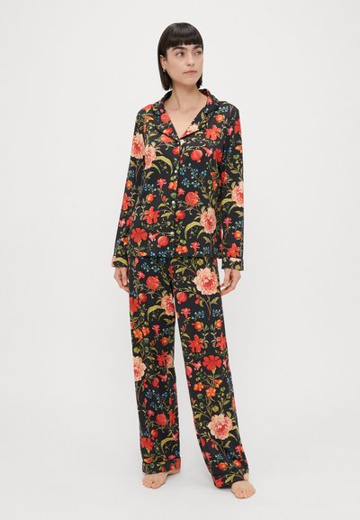 Cvjetni kompletić pidžame s crnom pozadinom, s velikim crvenim i ružičastim cvjetovima, zelenim lišćem i plavim naglašavanjima; izrađeno od mekanog materijala, slobodnog kroja.