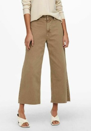 Beige vidde jeans med frynset kant, lavet af robust denim. Kombineret med cremede knyttede sandaler. Enkel og funktionel design.