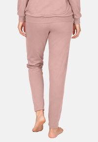 Puha, pihe rózsaszín szövetből készült leggings, karcsúsított szabással, elasztikus derékpánttal és szűkített szárakkal. Sima textúrájú és bokáig érő kialakítású.