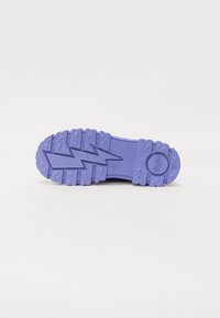 Suola di scarpa in gomma viola caratterizzata da un motivo di battistrada testurizzato con dettagli a zigzag e triangolari per una buona aderenza e trazione.