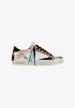 Sneaker z białą skórzaną cholewką, czarnymi zamszowymi akcentami i różowo-złotymi błyszczącymi detalami. Zawiera czarne sznurowadła i kolorową metkę.