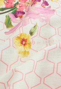 Balts audums ar rozā sešstūra rakstu, uz kura ir dzeltenas, rozā un violetas puķes ar zaļām lapām, nedaudz krokots.