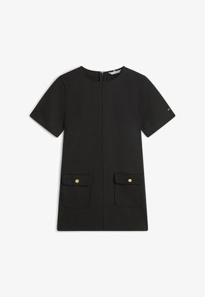 Zwarte jurk met korte mouwen, ritssluiting aan de voorkant, twee klepzakken met gouden knopen en een ronde halslijn op een witte achtergrond.