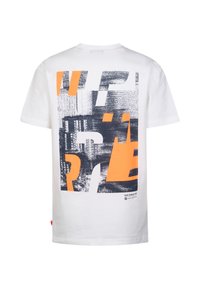 T-shirt en coton blanc avec un motif graphique aux nuances de bleu et d'orange, imprimé texturé et lettrage stylisé au dos.