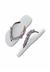 Witte flip-flops met een gestructureerde zool, paarse en gouden gevlochten bandjes versierd met heldere edelsteentjes, en een strakke tussenstuk ontwerp.