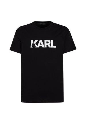 Juodas medvilnės marškinėlis su dideliu baltu užrašu "KARL" ir silueto grafika, apvaliu kaklu ir trumpomis rankovėmis. Paprastas, švarus dizainas.