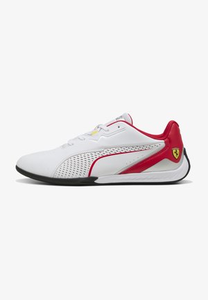 White athletic shoes with red accents, perforated design, and black soles. Features include a Ferrari logo and rounded toe shape.