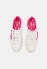 White leather sneakers featuring pink accents, a textured side detail, and a patterned pink insole with a logo. Laced design.
