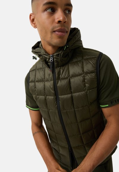 Gepolsterte olivgrüne Weste mit Kapuze, im gesteppten Design, schwarzen Reißverschlüssen und neongrünen Akzenten an den Ärmeln und dem Kragen.