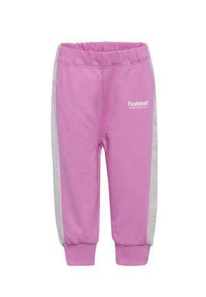Różowe dresy z szarymi panelami bocznymi, elastycznym paskiem w talii i ściągaczami przy nogawkach. Zawierają białe logo "hummel SPORTSWEAR". Miękka tekstura materiału.