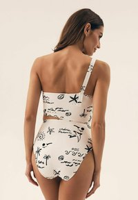 Biały zestaw bikini z czarnymi nadrukami o tematyce plażowej, z topem na jedno ramię i wysokim stanem majtek. Gładki, rozciągliwy materiał.