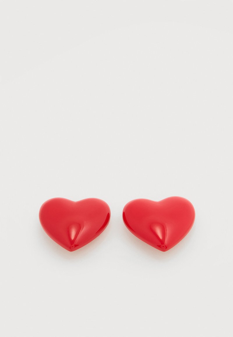 Boucles d'oreilles en forme de cœur rouge avec une finition brillante, présentant des courbes lisses et un design sans couture. Aucun élément visible ni détail complexe.