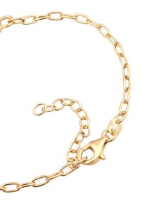 Guldfärgad kedjennäcka med ovala länkar, utrustad med en kräftklämma. Kännetecknande för sin släta yta och glänsande finish.