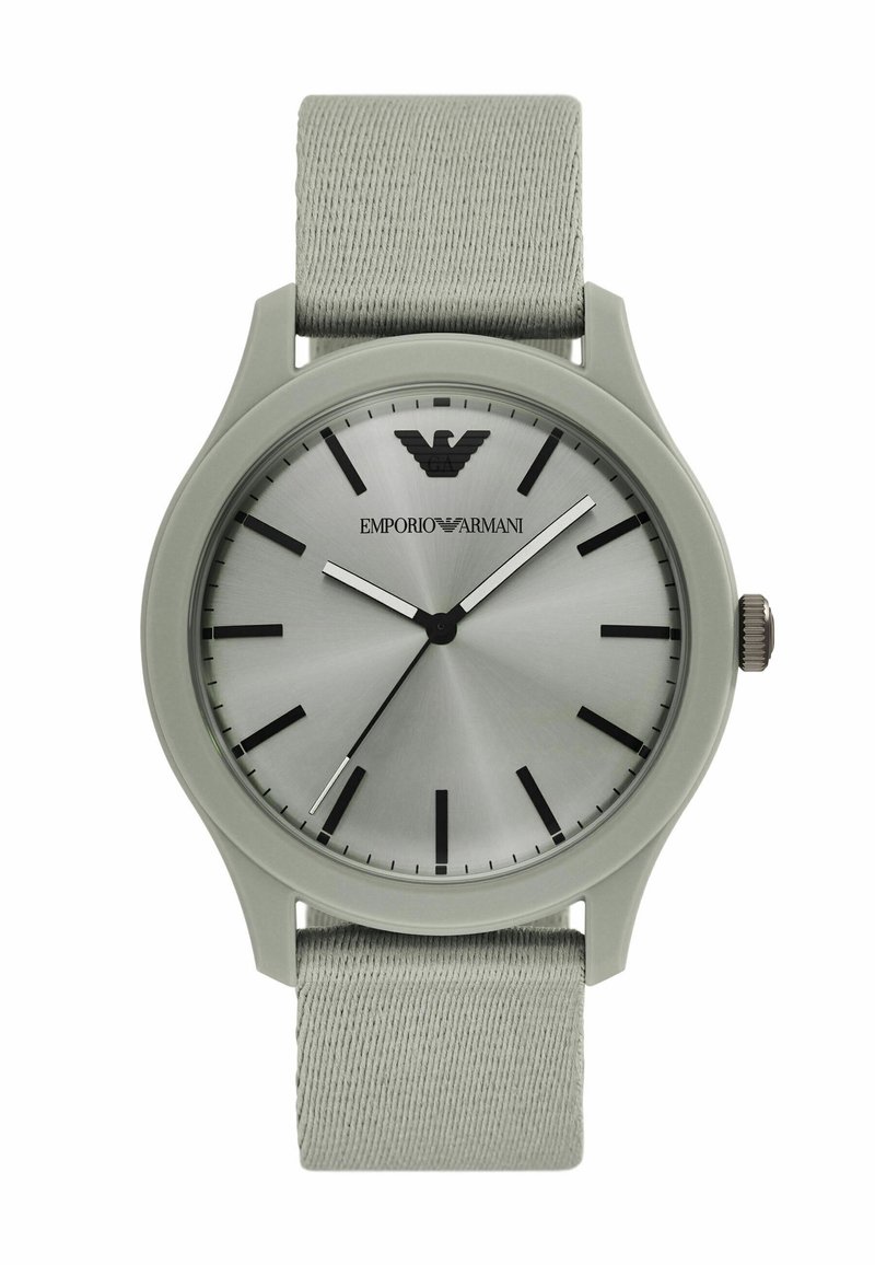 Montre au cadran argenté avec des index noirs, boîtier en silicone gris et bracelet en tissu gris clair. Elle affiche un logo de la marque à 12 heures.