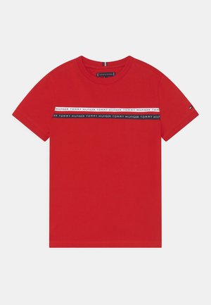 Rød kortærmet t-shirt med rund hals og to vandrette striber over brystet med gentagende Tommy Hilfiger tekst.