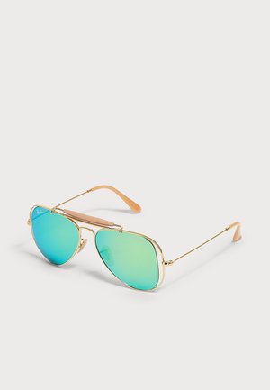 Une paire de lunettes de soleil aviateur à monture dorée avec des verres miroir bleu-vert posée sur une surface plane.