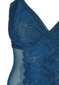 Costume da bagno blu scuro con sovrapposizione in pizzo che presenta motivi a foglia. Design a V e pannelli laterali lisci. Tessuto morbido e leggermente trasparente.