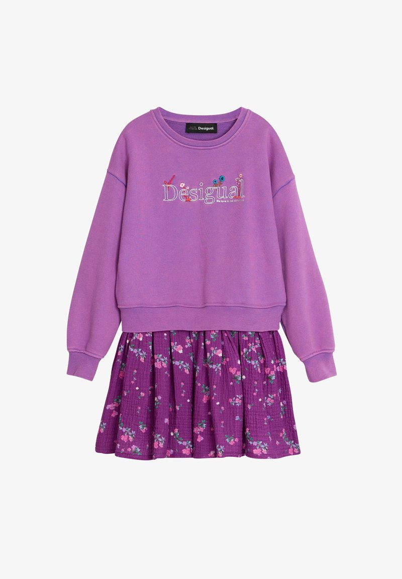 Lila Sweatshirt mit dem eingestickten Schriftzug "Desigual", kombiniert mit einem mehrlagigen lila Rock mit floralem Muster in Pink und Grün.