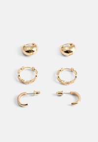 Ensemble de boucles d'oreilles dorées comprenant des créoles en forme de cœur, des créoles à maillons texturés, une simple puce et une pièce incurvée avec des accents clairs.